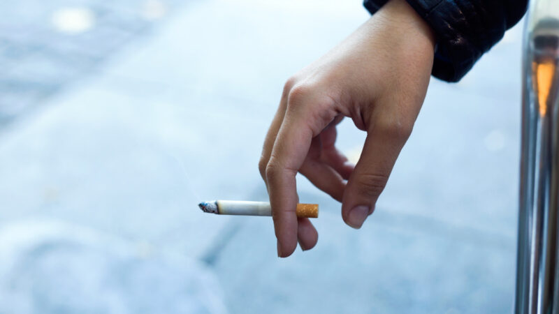 Moteris su cigarete gatvėje rukymo pertraukos darbe