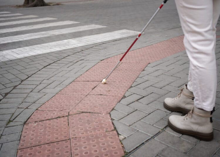 Aklasis vaikščiojantis po miestą su aklųjų lazdele