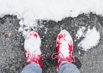 Asmens kojos su batais ant asfalto šalia sniego ziema sniegas ledas