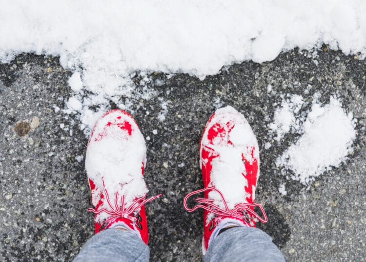 Asmens kojos su batais ant asfalto šalia sniego ziema sniegas ledas