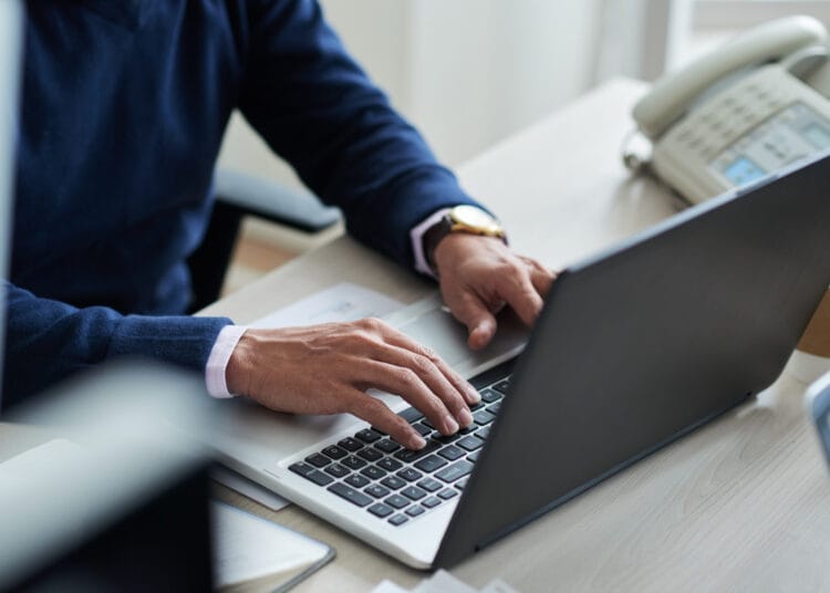 Darbuotojo dirbančio su nešiojamuoju kompiuteriu vaizdas dideliu kampu kada nereikia moketi vsd