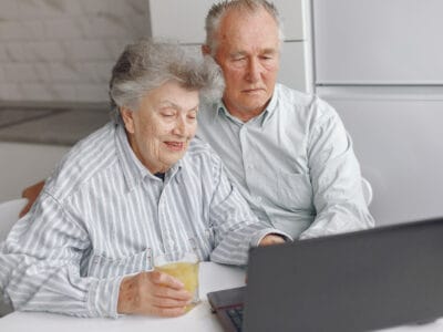 Elegantiška sena pora sėdi namuose ir naudojasi nešiojamuoju kompiuteriu kaip sustabdyti pensijos kaupima seb
