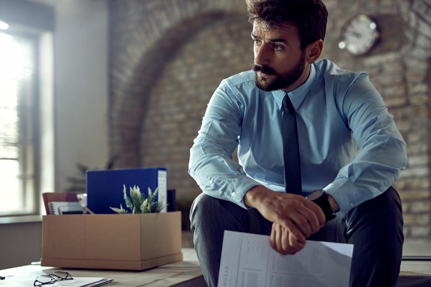 Jaunas nusiminęs verslininkas sėdi biure ir mąsto po to kai buvo atleistas iš darbo kaip apskaiciuoti nedarbo ismoka