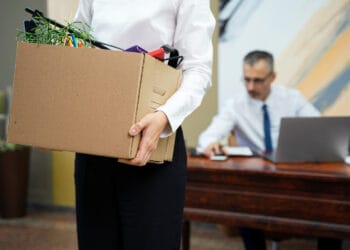 Moteris nešanti kartoninę dėžę vaizdas iš šono atleidimas už pravaikštas