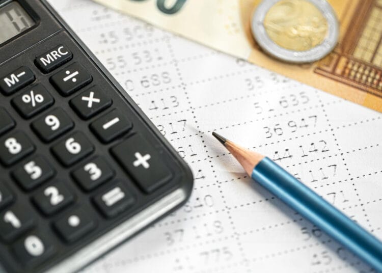 Skaičiuoklės pinigai ir pieštukas stambiu planu neryškiame fone individualios veiklos mokesciai