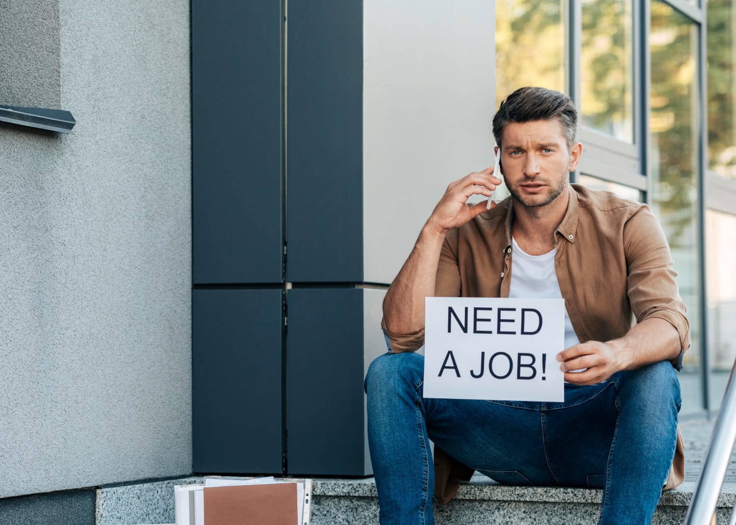 Vidutinio dydžio kadras kai bedarbis kalba telefonu kada pakartotinai mokama bedarbio pasalpa