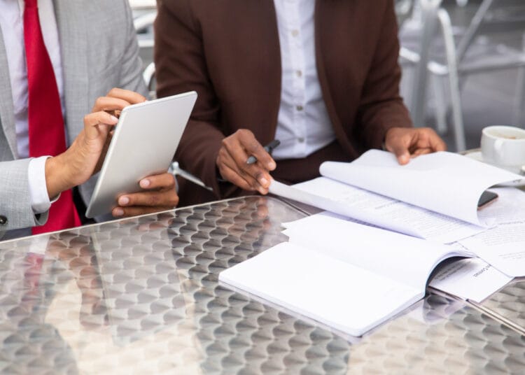 Apkarpytas dviejų verslininkų dirbančių su dokumentais kadras viesieji pirkimai