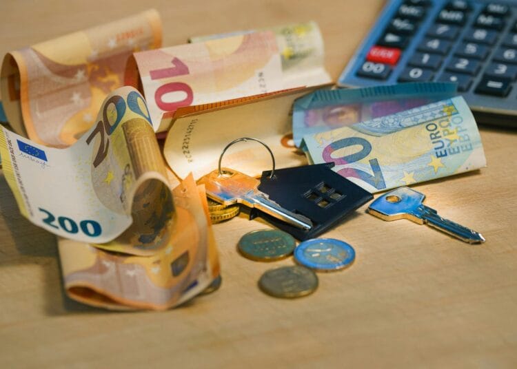 Euro banknotai ir raktai ant medinio paviršiaus kas turi mokėti nekilnojamojo turto mokestį