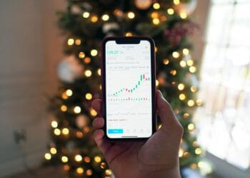 Juodą Android išmanųjį telefoną laikantis asmuo investavimas investicijos