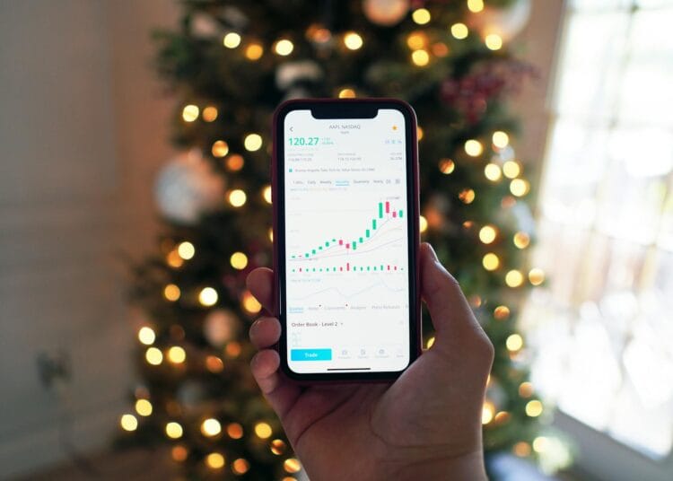 Juodą Android išmanųjį telefoną laikantis asmuo investavimas investicijos