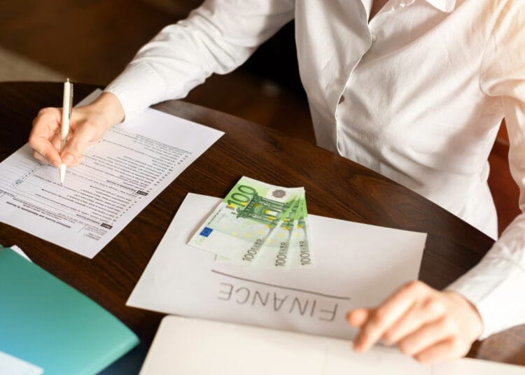 Moteris dirba su finansais ant stalo Pinigai dokumentai kiek kainuoja verslo liudijimas buto nuomai vilniuje