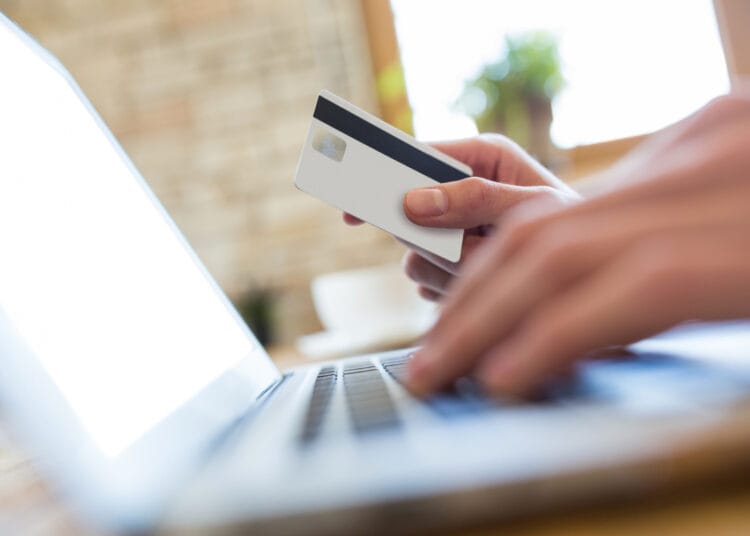 Ranka naudojanti nešiojamąjį kompiuterį internetiniam mokėjimui kavinėje atlikti kaip moketi psd savarankiskai