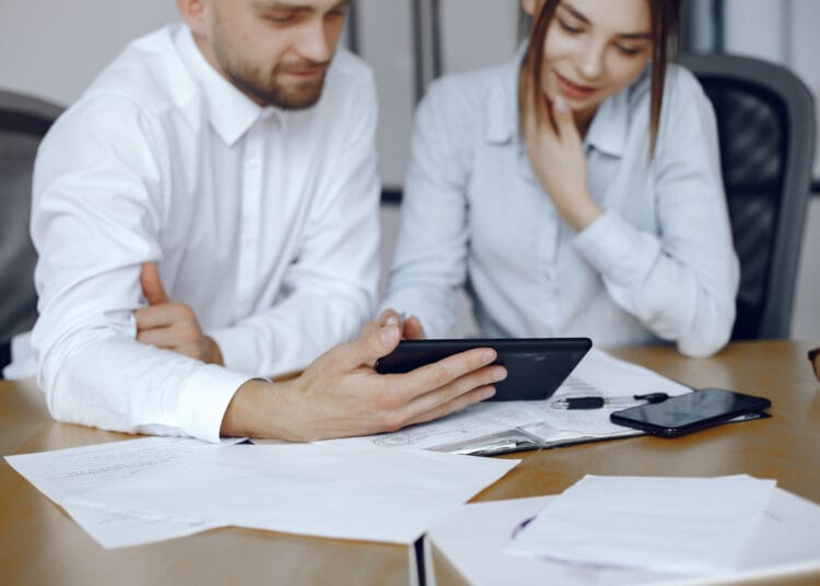 Vyras su planšetiniu kompiuteriu Verslo partneriai verslo susitikime Prie stalo sėdintys žmonės kada mokamas pelno mokestis