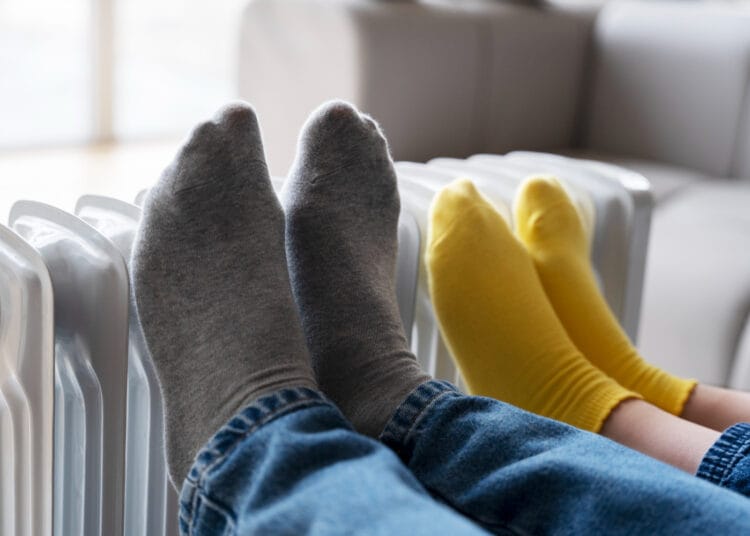 Žmonių kojų šildymas ant šildytuvo