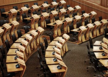 Horizontalus kadras kuriame matomi stalai Škotijos parlamento pastato viduje seimas