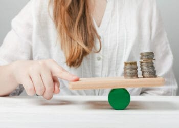 Moteris balansuojanti pirštą su monetomis kaip skaiciuojamas vidutinis darbo uzmokestis