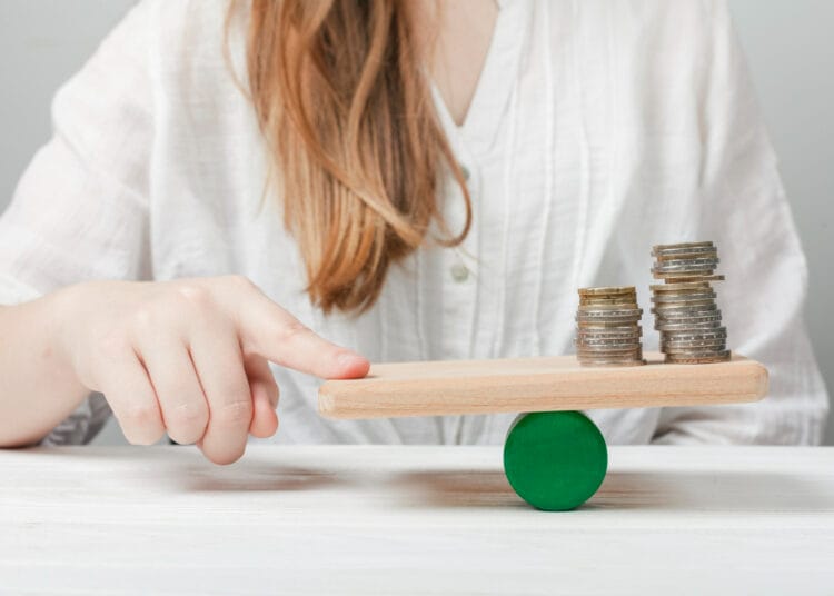 Moteris balansuojanti pirštą su monetomis kaip skaiciuojamas vidutinis darbo uzmokestis